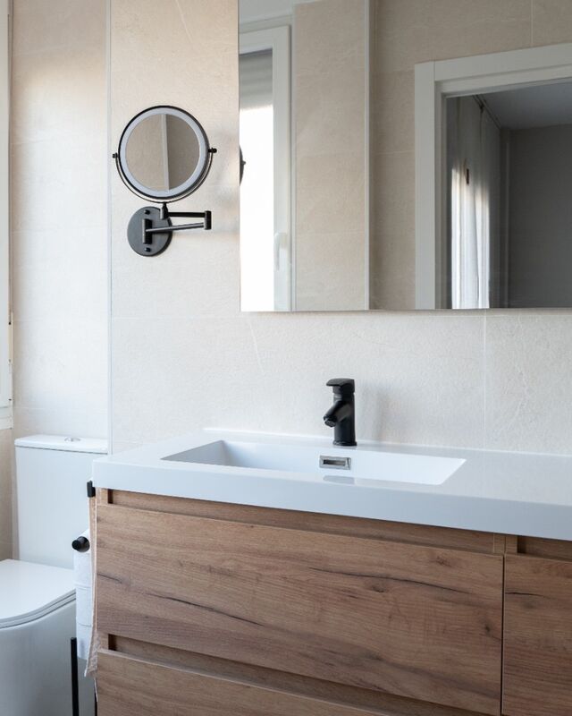 Espejo de gran formato y espejo de aumento con luz sobre el lavabo
